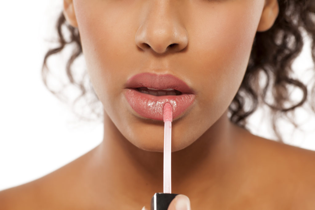 Woman applying Lip gloss for subtle shine